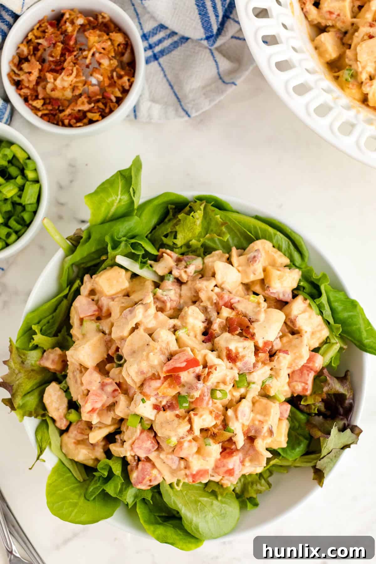 Crisp BLT Chicken Salad 6 Large bowl of Chicken BLT Salad garnished with fresh herbs, ready to serve.