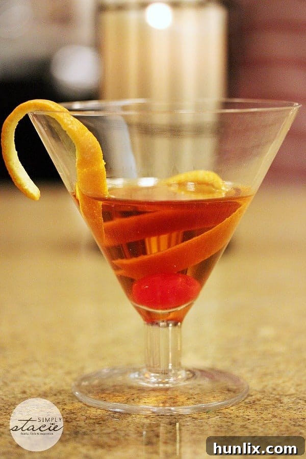 A close-up of an Appleton Estate Manhattan, showcasing its vibrant color and elegant cherry garnish, ready to be enjoyed.
