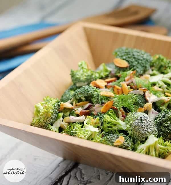 Vibrant broccoli salad with homemade ranch dressing, featuring fresh broccoli florets, crispy bacon bits, red onion, golden raisins, and sliced almonds. Ideal for dairy-free diets.