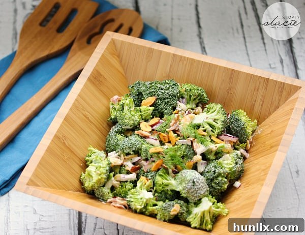 Close-up of creamy homemade ranch dressing being poured over fresh broccoli salad ingredients, highlighting the dairy-free aspect and rich texture.