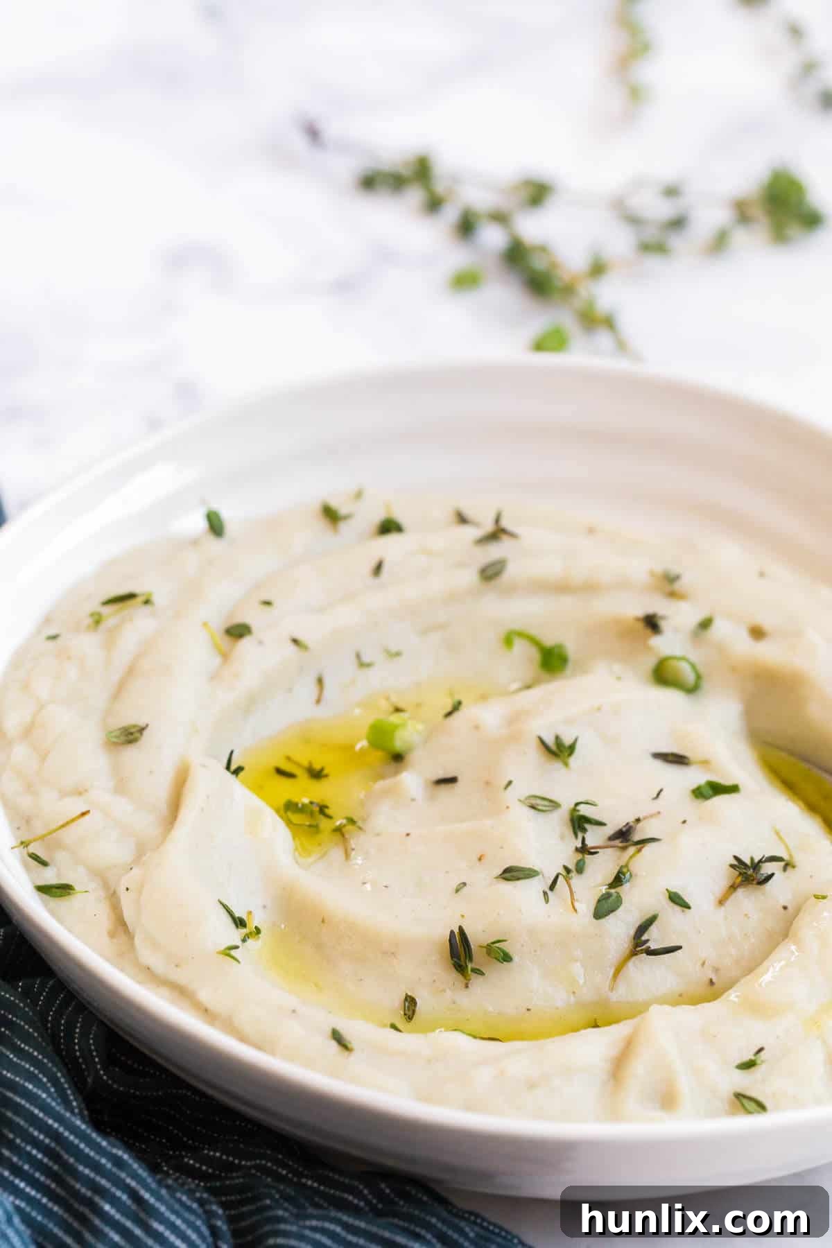 Creamy Vegan Cauliflower Mash 5 A beautifully presented bowl of creamy vegan mashed cauliflower, ready to be served, emphasizing its appetizing texture and appealing color.