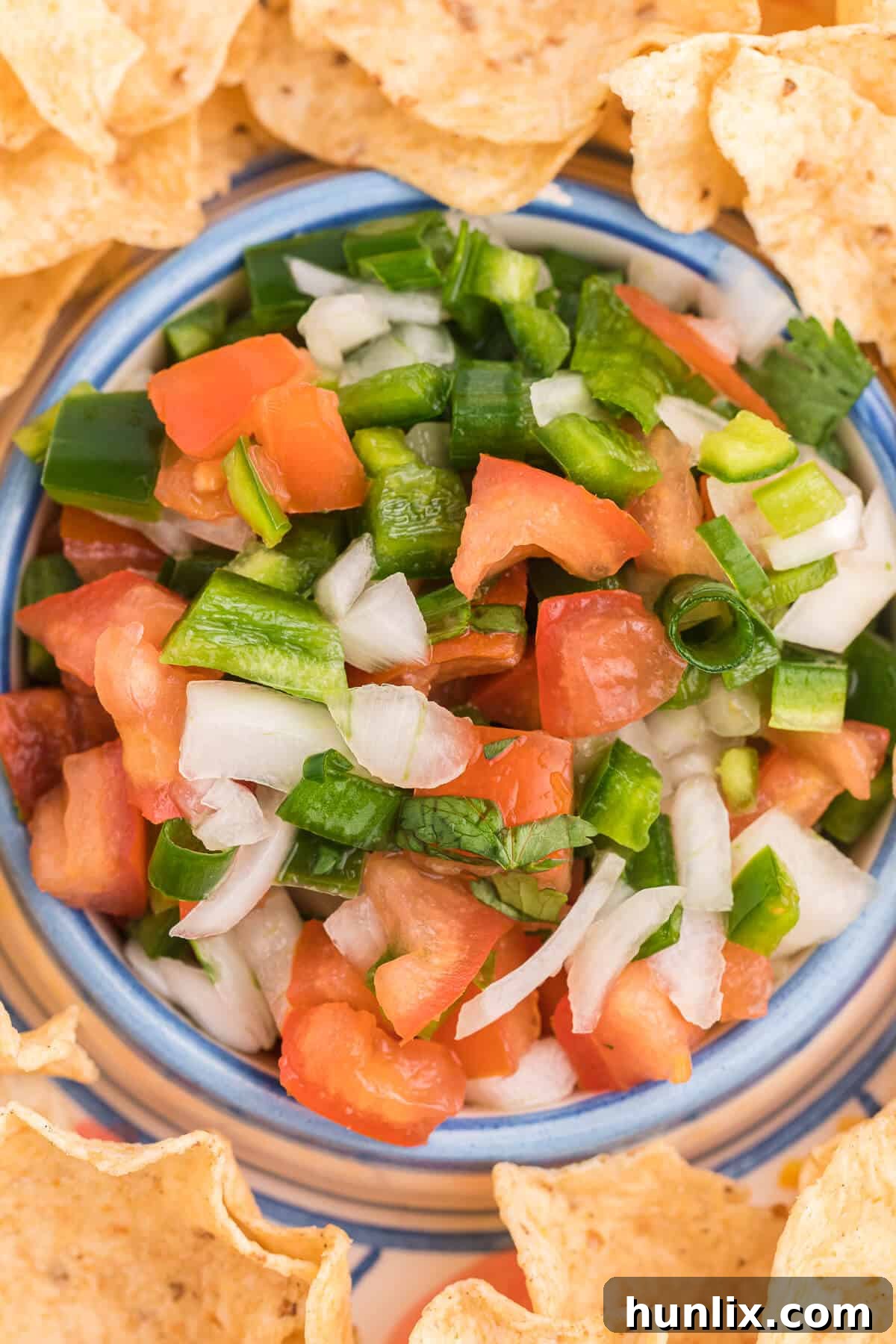 A vibrant close-up of fresh Pico de Gallo served in a small white bowl, demonstrating the perfect texture and color of the finely chopped ingredients, ready to be enjoyed.