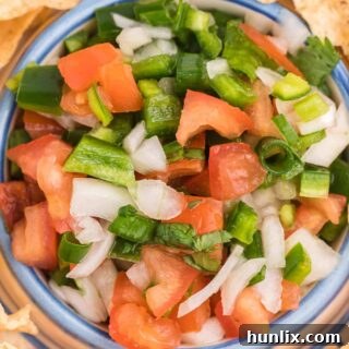 A close-up of a homemade recipe card for Pico de Gallo, detailing ingredients and instructions, set against a rustic background, suggesting a simple, cherished recipe.