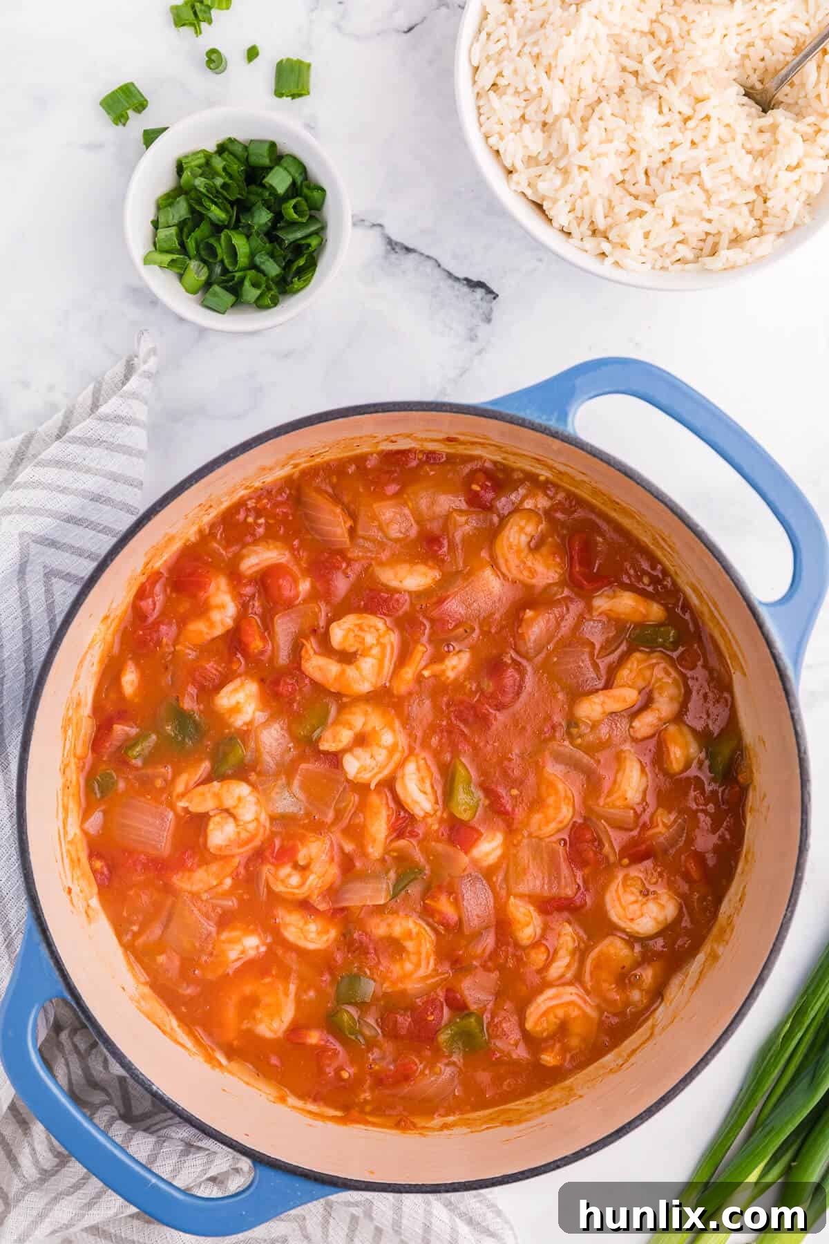 A delicious bowl of Shrimp Creole in a blue Dutch oven, ready to be served over rice.