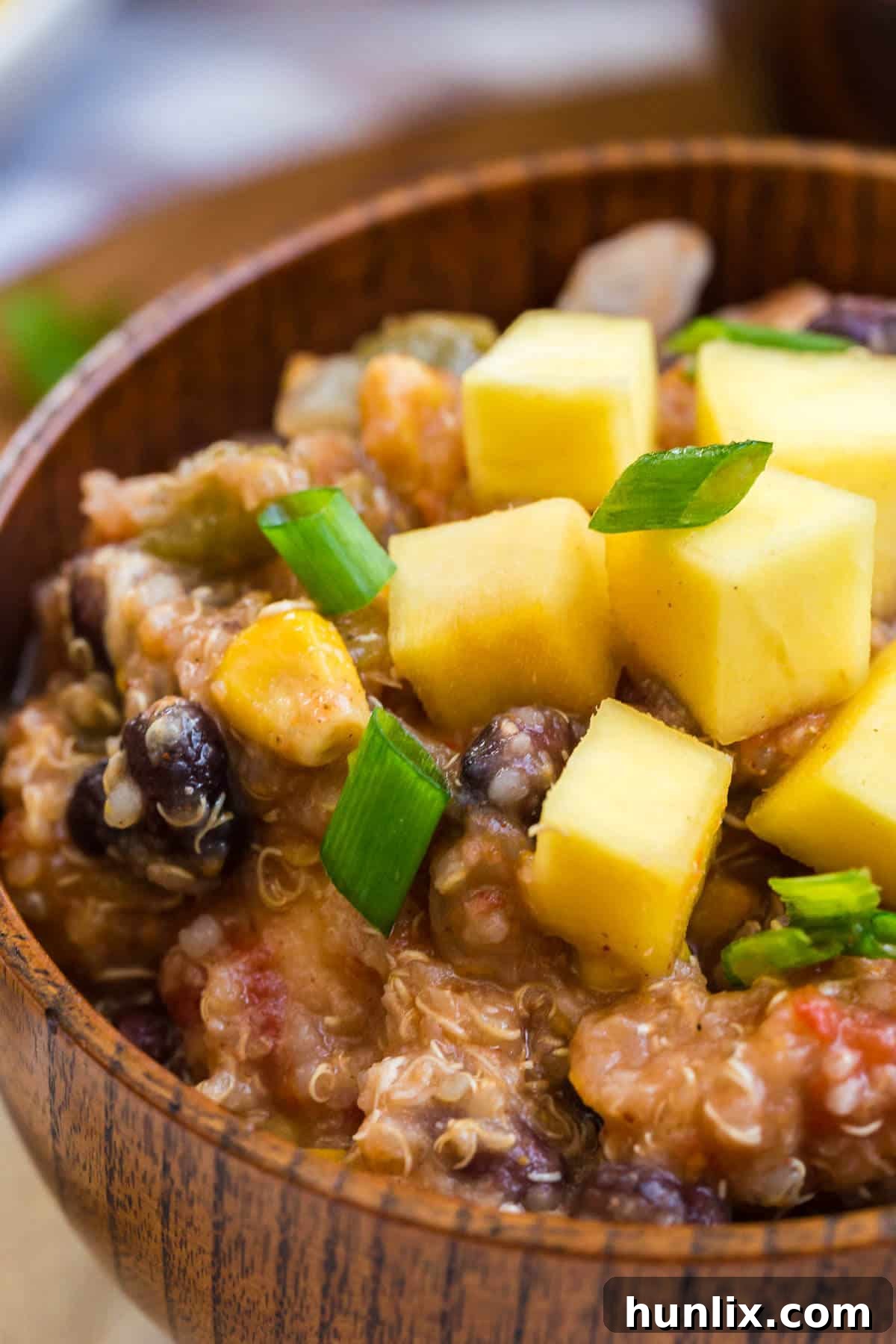 A beautifully presented bowl of homemade chicken quinoa chili, garnished with fresh cilantro and lime.
