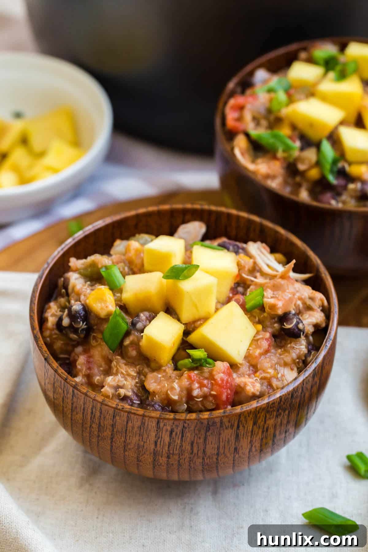 Four individual bowls of slow cooker chicken quinoa chili, ready to be served.