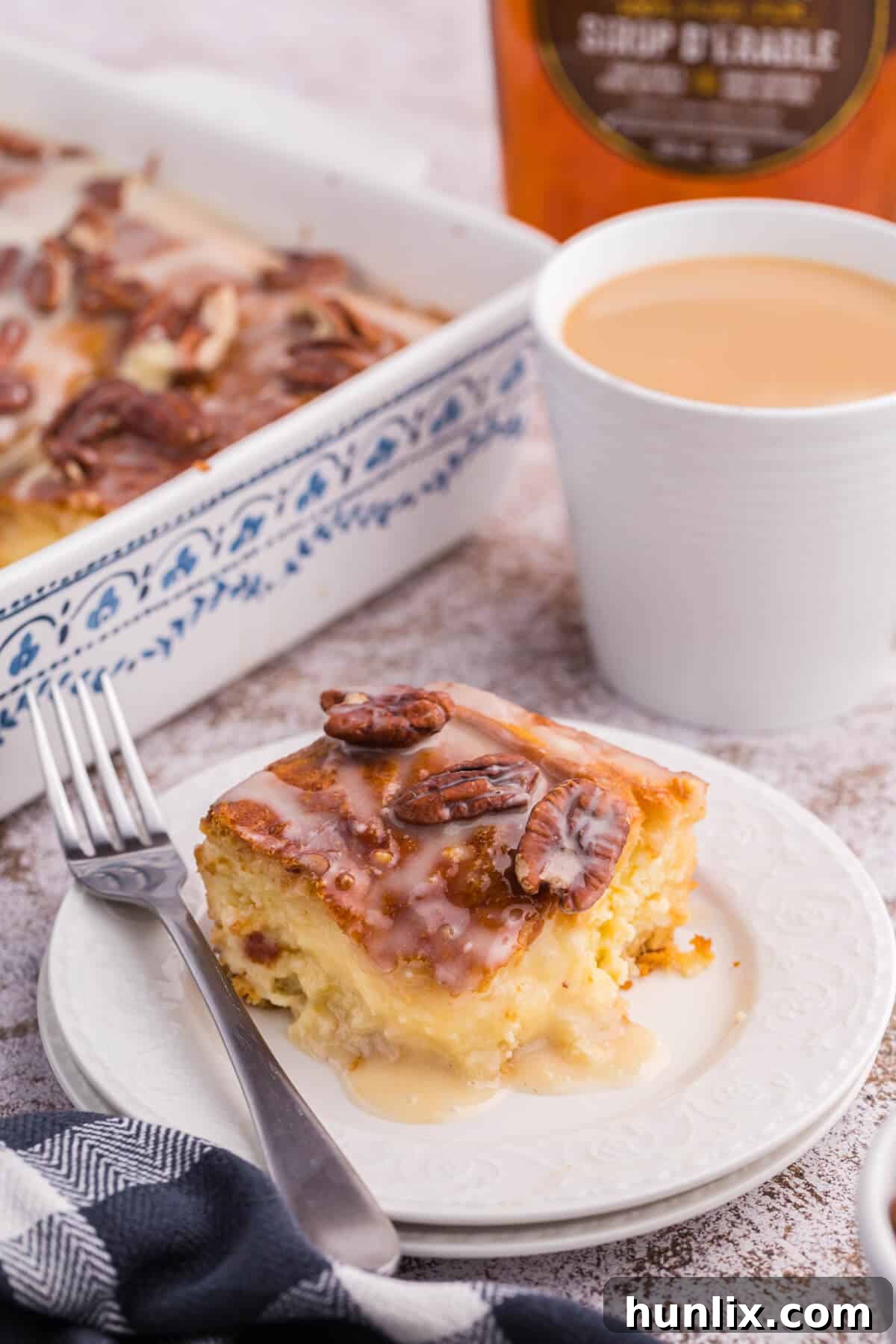 A perfectly portioned slice of maple pecan danish bake on a white plate, served with a fork.