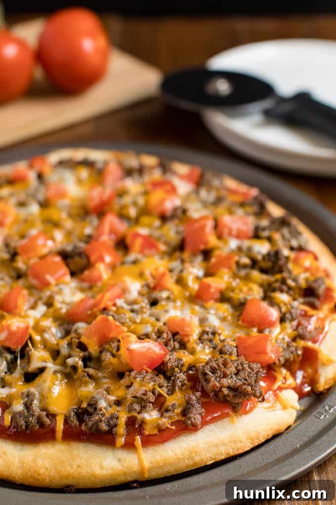 Cheeseburger pizza on a pizza pan.