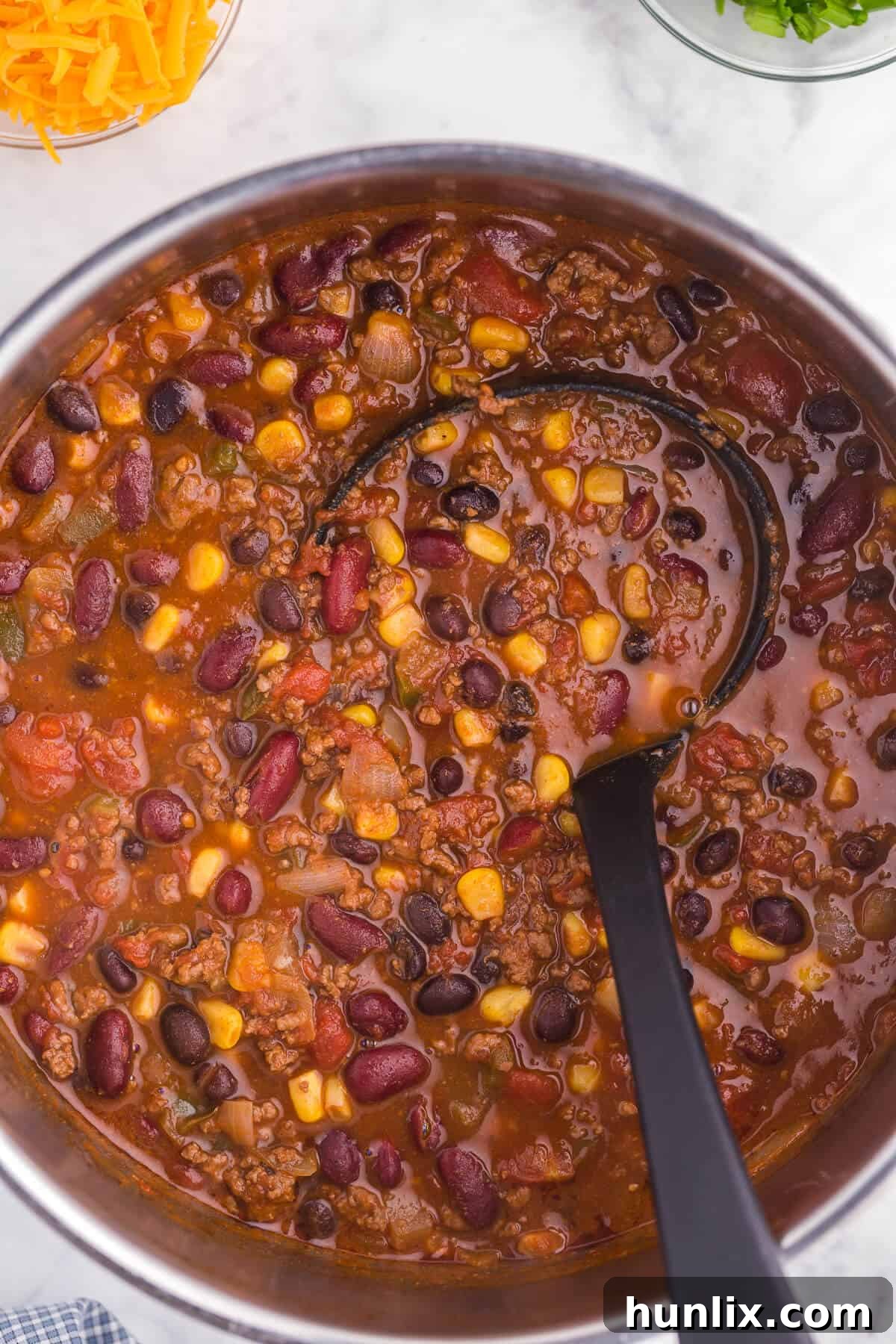 Pantry Chili - A simple, hearty soup made with just pantry staples! This beefy chili recipe is packed with corn, black beans, tomatoes, and kidney beans with a homemade seasoning blend for the best homemade chili recipe.