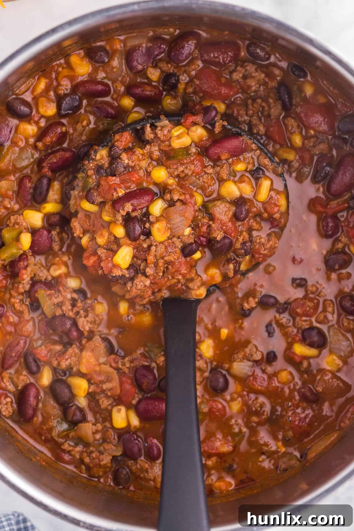 Pantry Chili - A simple, hearty soup made with just pantry staples! This beefy chili recipe is packed with corn, black beans, tomatoes, and kidney beans with a homemade seasoning blend for the best homemade chili recipe.