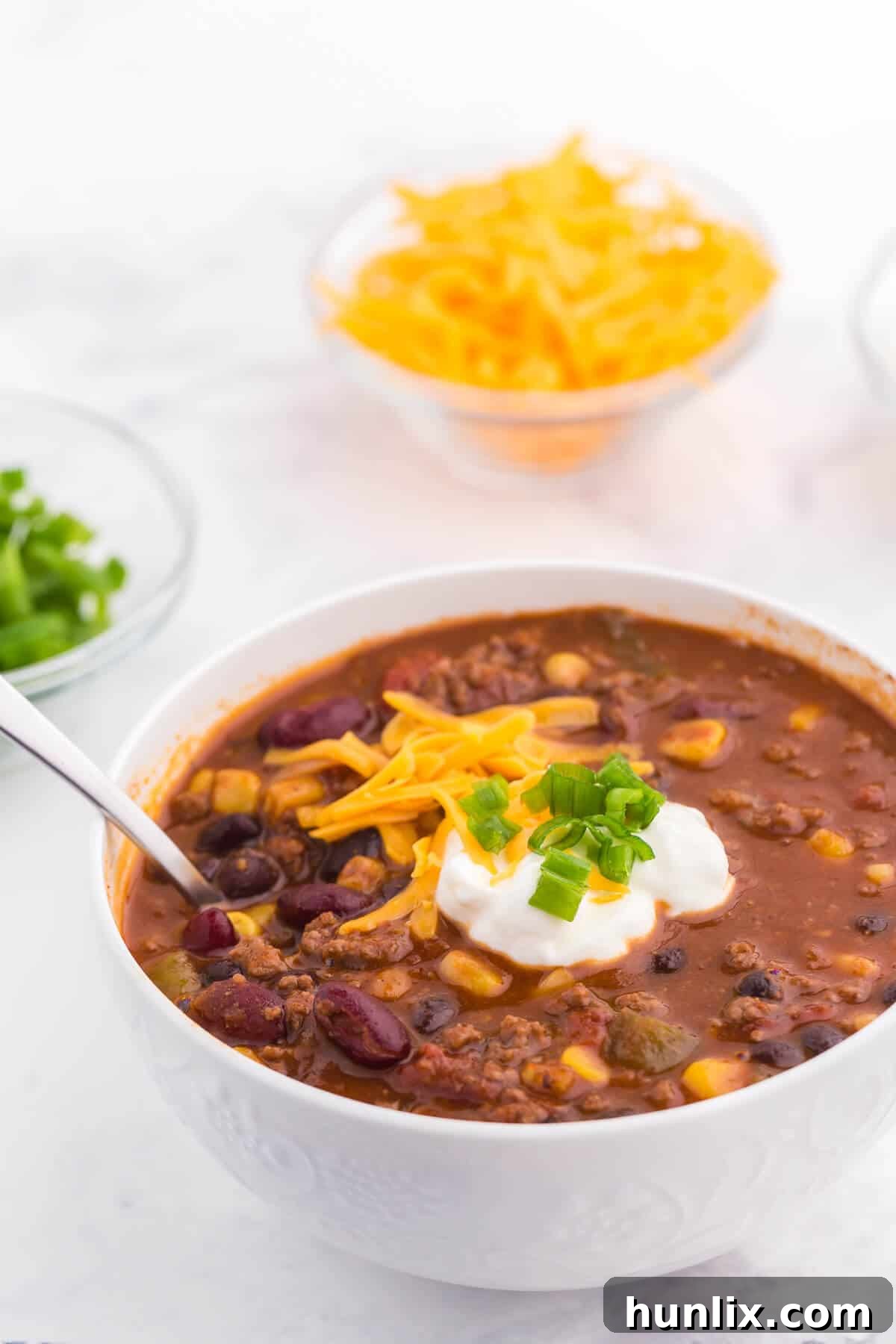 Pantry Chili - A simple, hearty soup made with just pantry staples! This beefy chili recipe is packed with corn, black beans, tomatoes, and kidney beans with a homemade seasoning blend for the best homemade chili recipe.