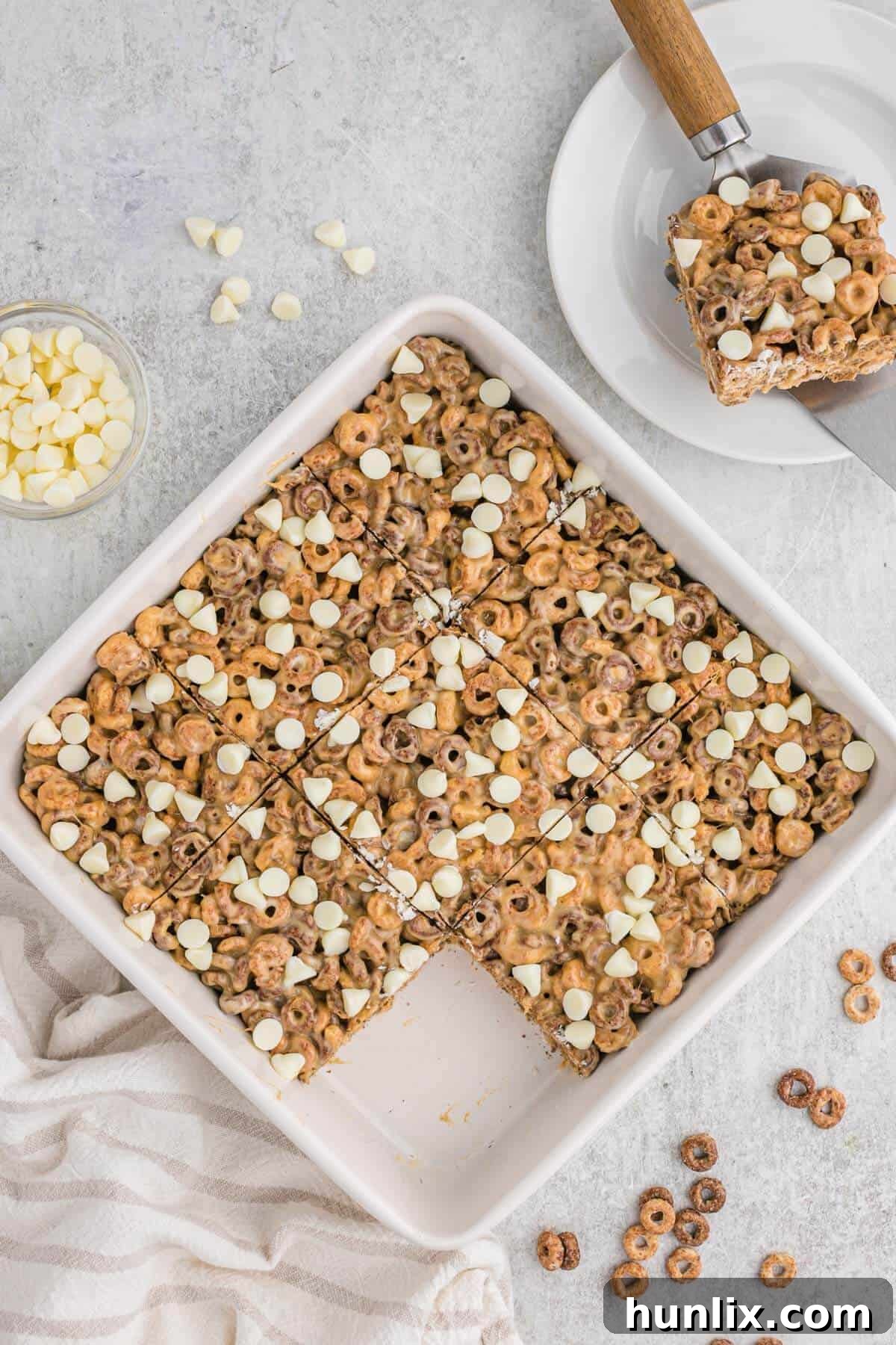 No Bake White Chocolate Peanut Butter Cheerios Squares 2 Decadent White Chocolate Peanut Butter Cheerios Treats cooling in a baking pan, showcasing their rich texture and tempting layers.