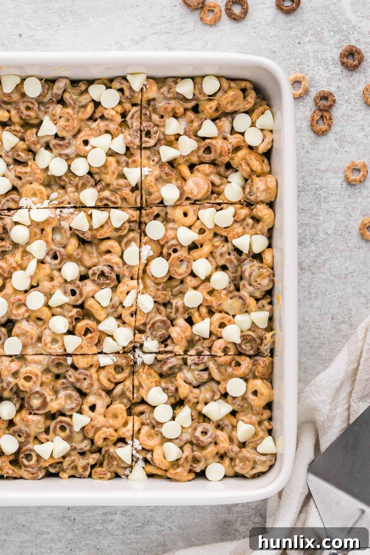 No Bake White Chocolate Peanut Butter Cheerios Squares 5 Close-up of freshly made white chocolate peanut butter Cheerios treats, glistening with melted marshmallow and peanut butter, still in the pan.