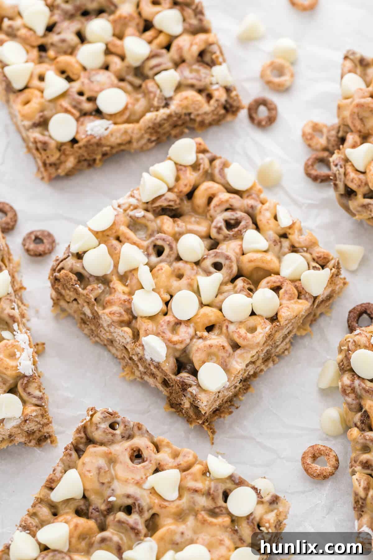 No Bake White Chocolate Peanut Butter Cheerios Squares 7 White Chocolate Peanut Butter Cheerios Treats neatly cut into individual bars on a cutting board, ready for serving.