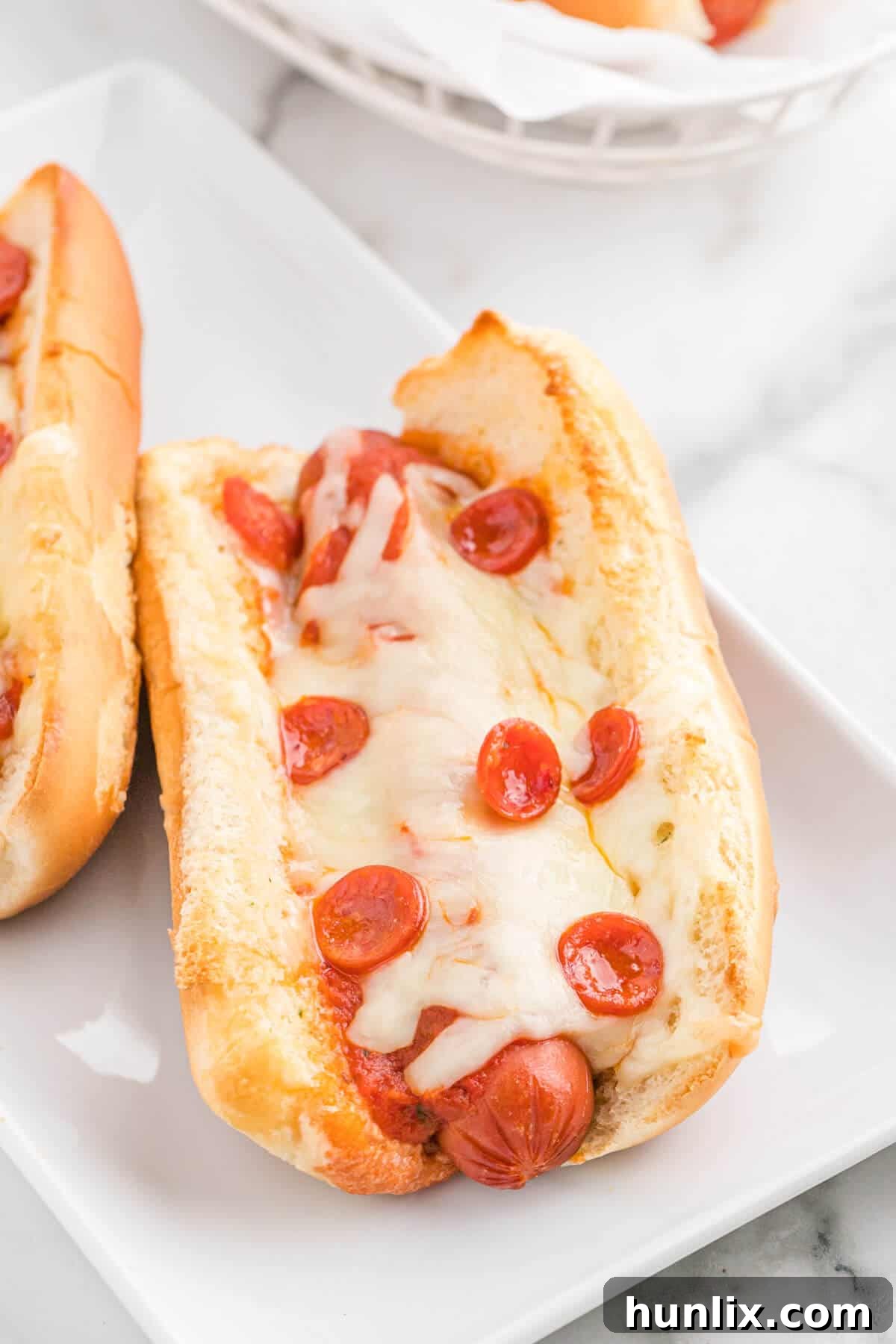 Pizzadog 8 A platter of finished pizza hot dogs, garnished and ready for serving.