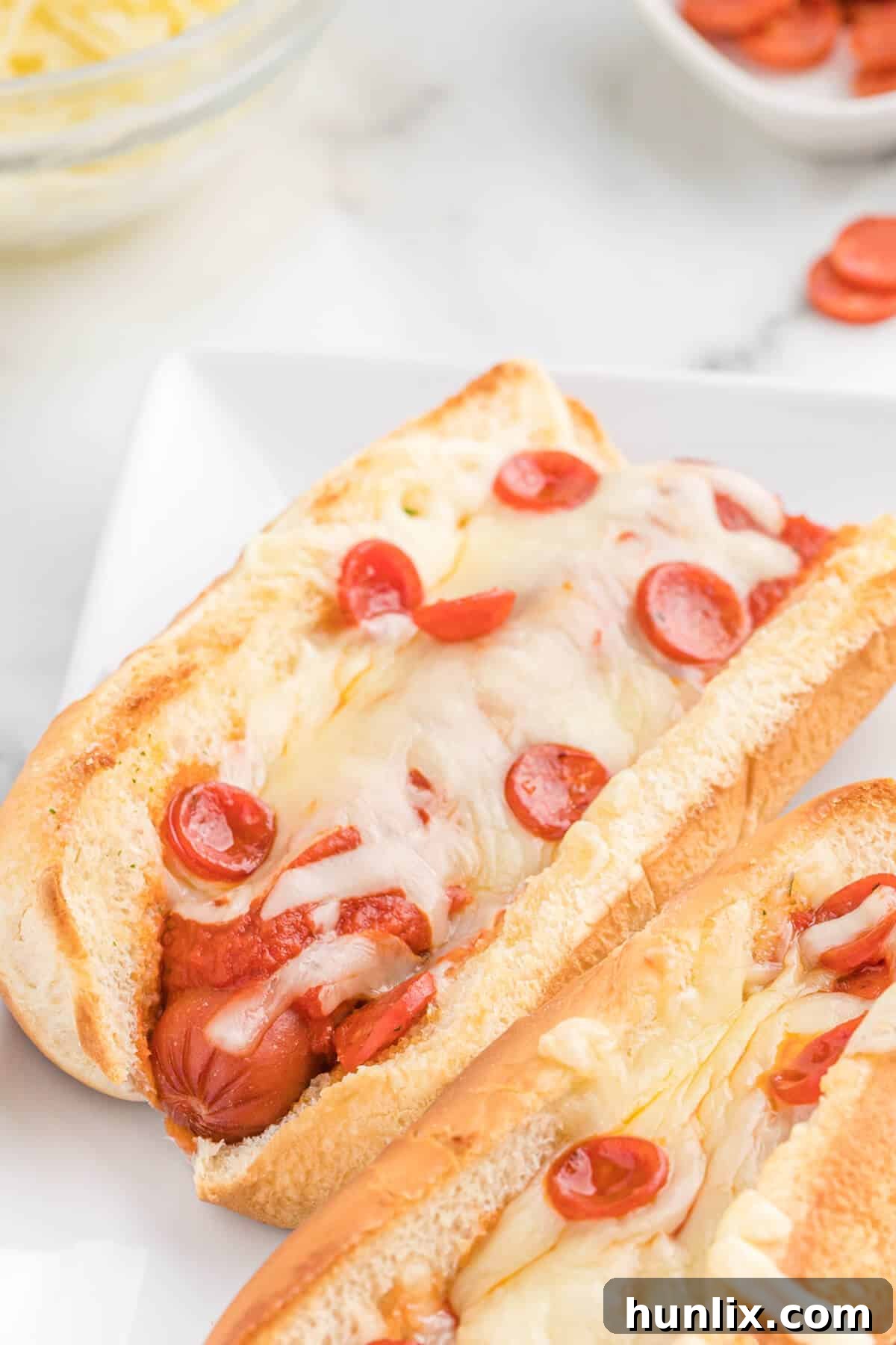 Pizzadog 9 A close-up of two pizza hot dogs, showing the rich toppings and melted cheese.