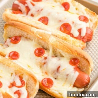 Pizzadog 10 A tray of freshly baked pizza hot dogs with melted cheese and pepperoni.