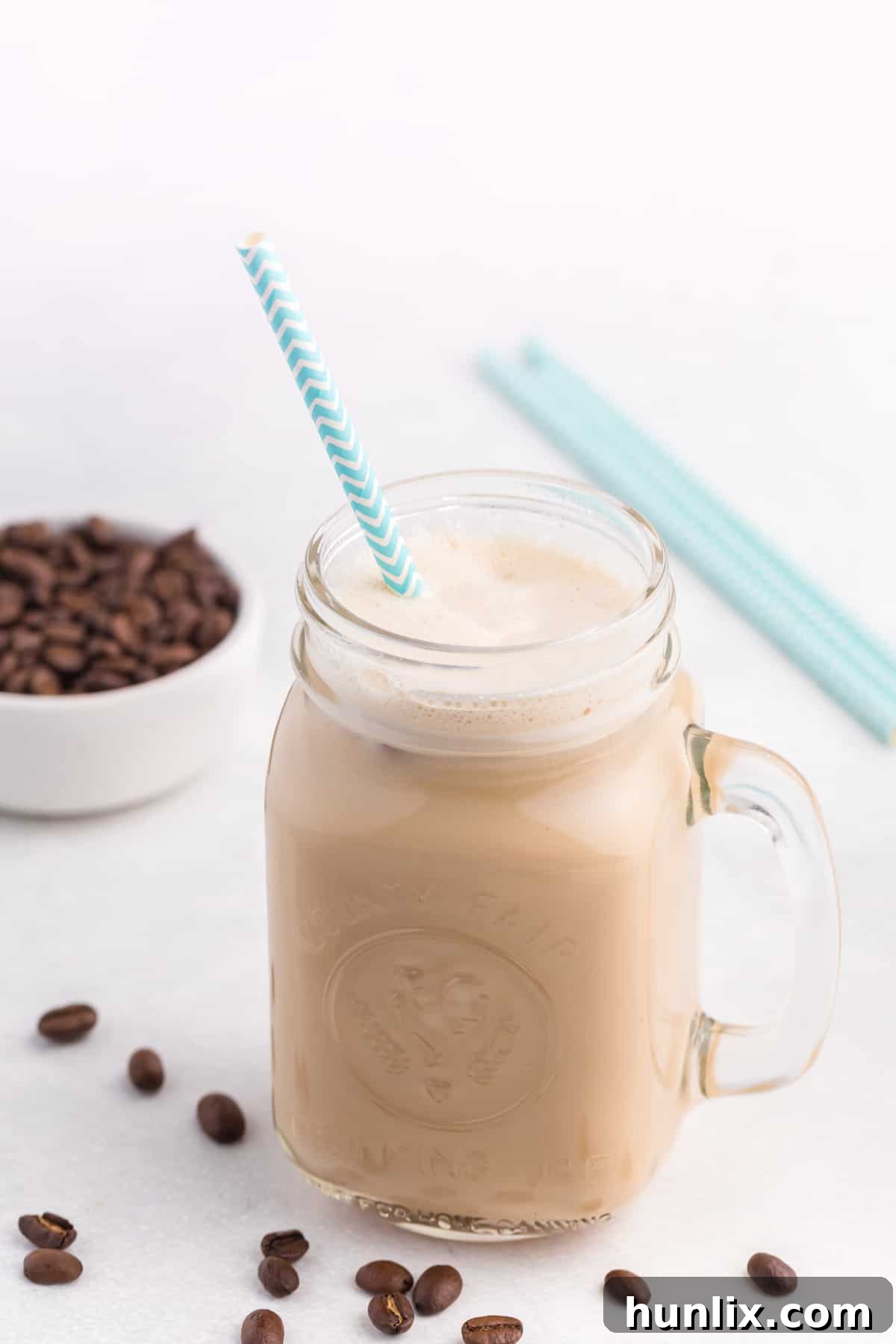 A glass jar with iced coffee and a straw, promising a refreshing escape.