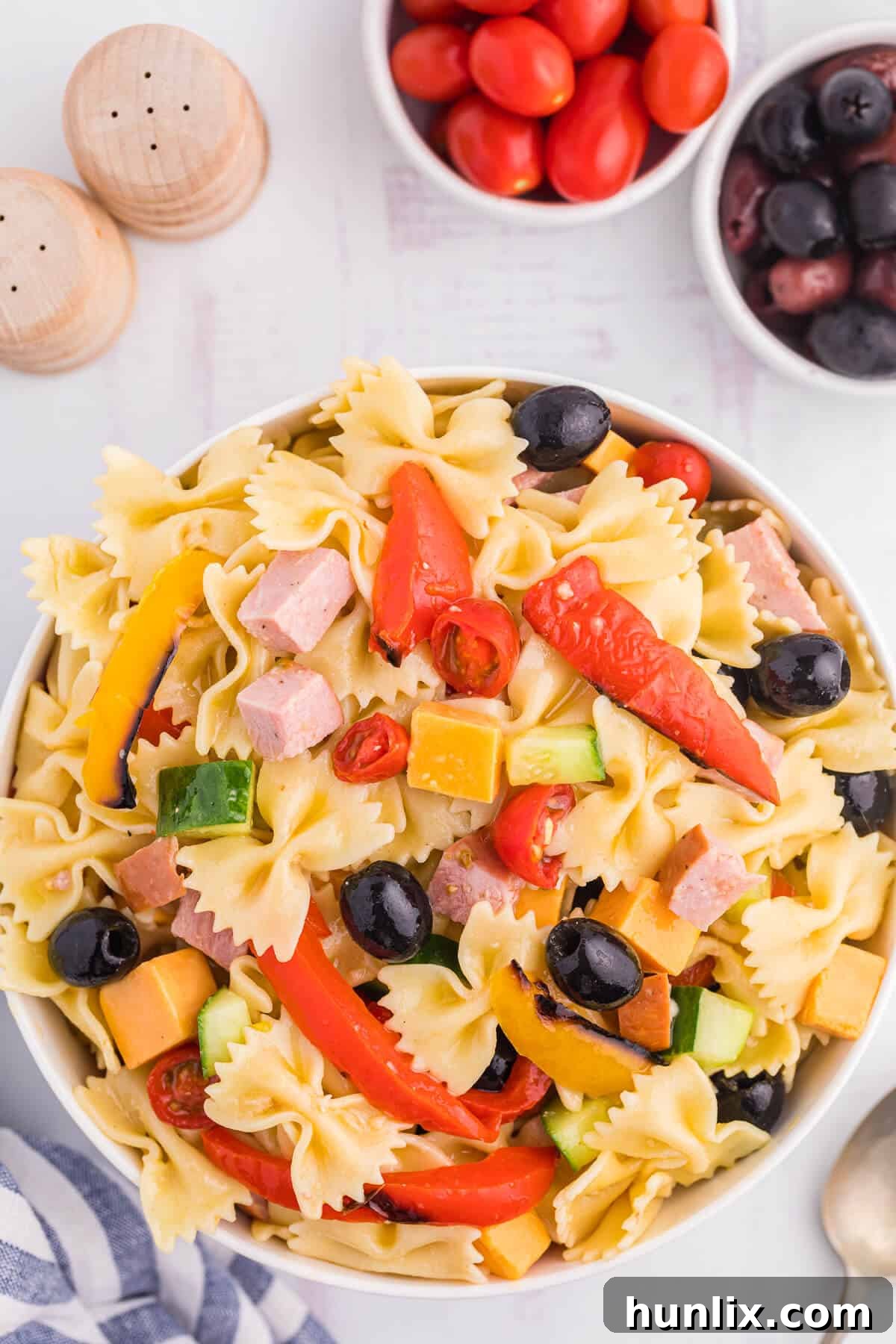 Blistered Bell Pepper Pasta Toss 2 A bowl of vibrant roasted red pepper pasta salad, garnished with fresh herbs.