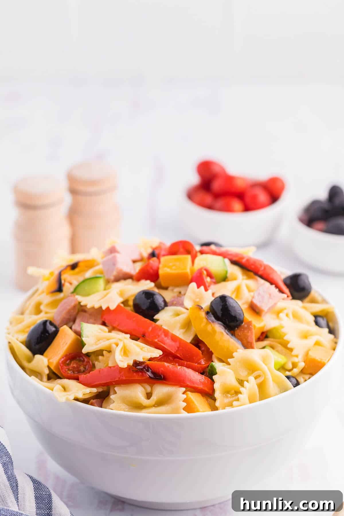 Blistered Bell Pepper Pasta Toss 3 A close-up shot of roasted pepper pasta salad in a white bowl, showcasing the textures.