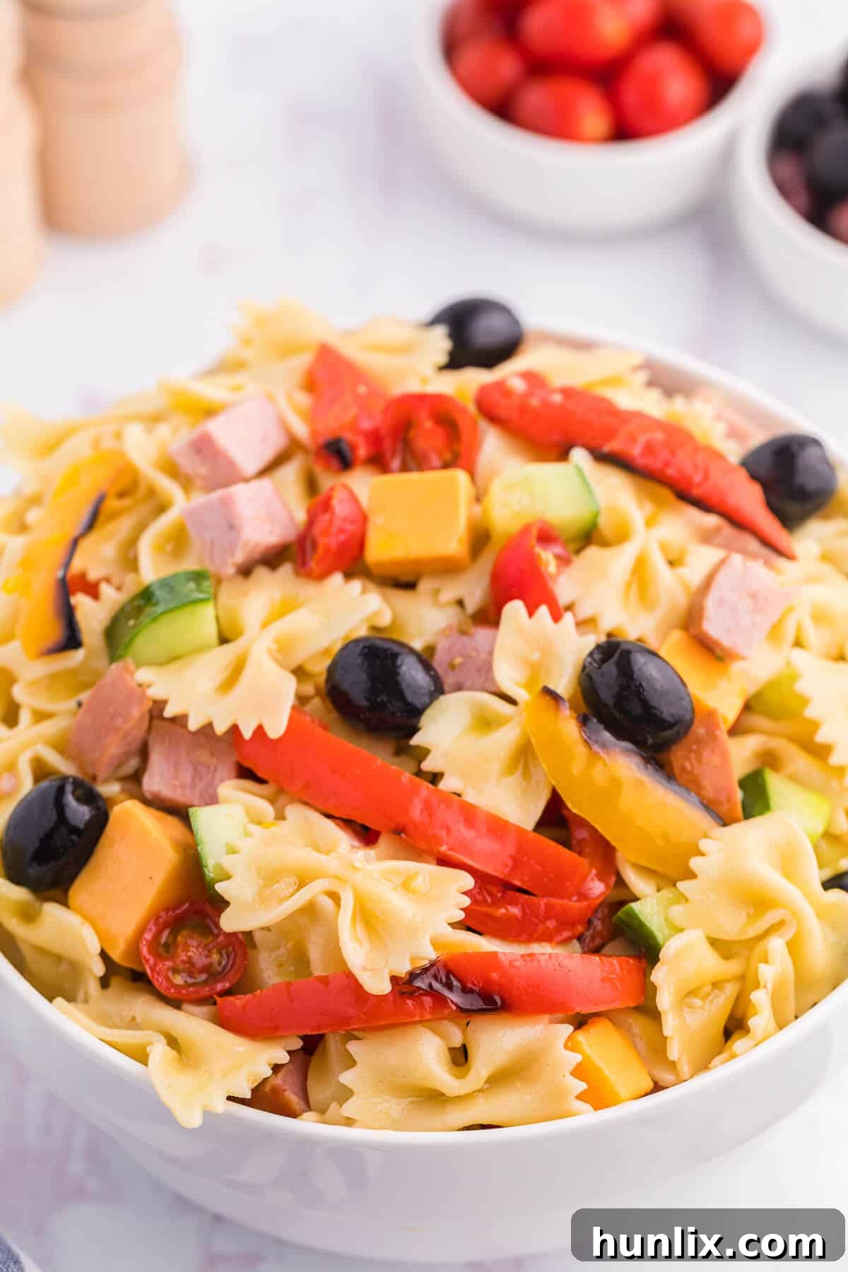 Blistered Bell Pepper Pasta Toss 5 A close-up of roasted pepper pasta salad in a bowl, showing the colorful ingredients.