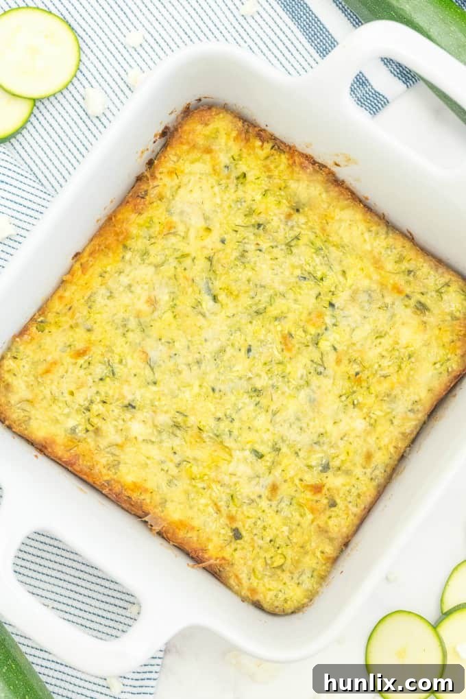 A vibrant Cheesy Zucchini Bake, golden brown and bubbling with melted cheese, ready to be sliced and served. Perfect for using up summer zucchini.