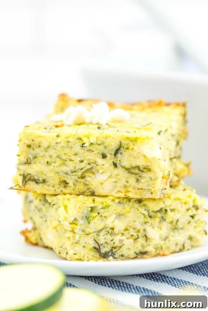 A beautifully presented Cheesy Zucchini Bake, sliced and ready for serving in a rustic setting.