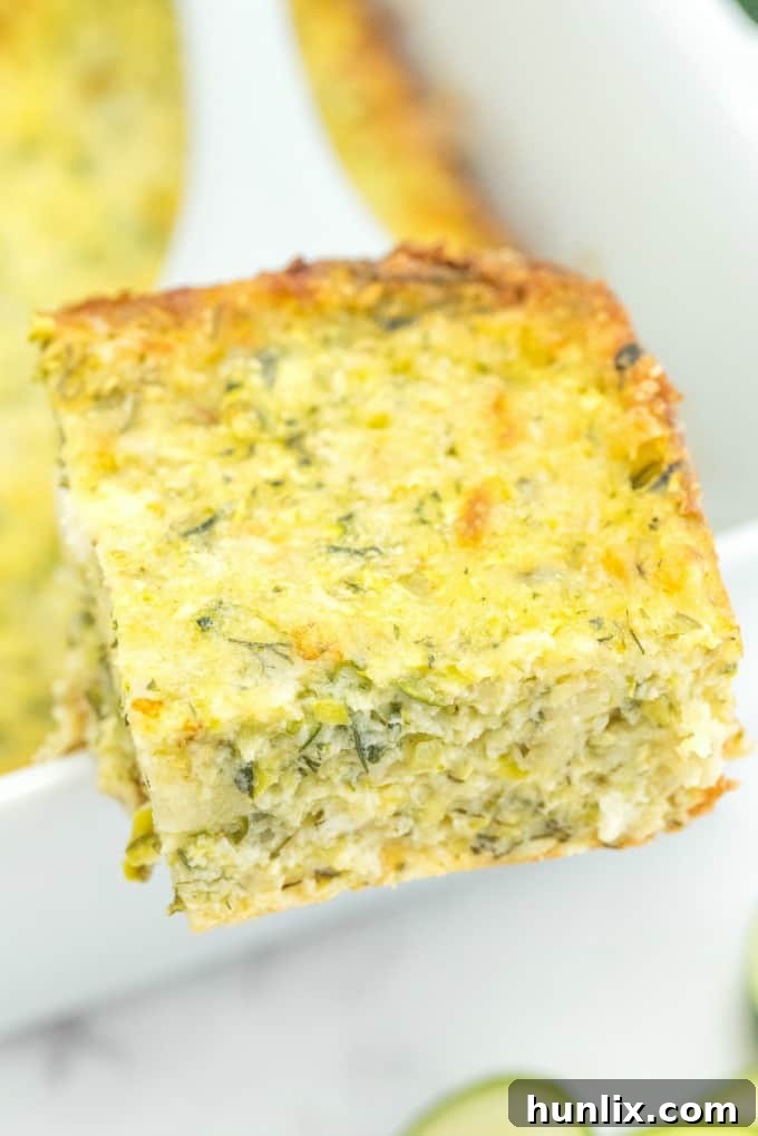 A golden-brown Cheesy Zucchini Bake, fresh out of the oven, with a slight golden crust and melted cheese visible.