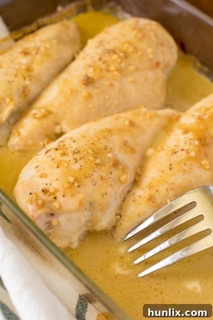 Golden Honey Garlic Chicken 7 A close-up shot of Honey Garlic Chicken in a pan, with a fork piercing a tender piece of chicken.