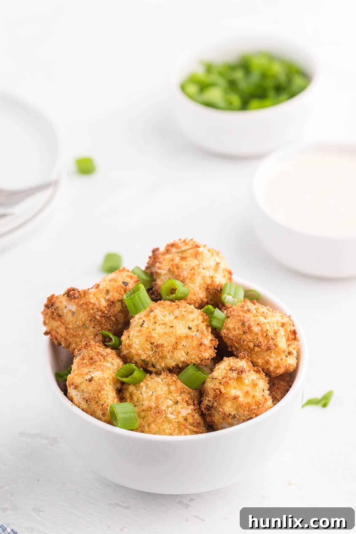 A closer view of the golden and perfectly seasoned Air Fryer Cauliflower Bites in a clean white serving bowl.