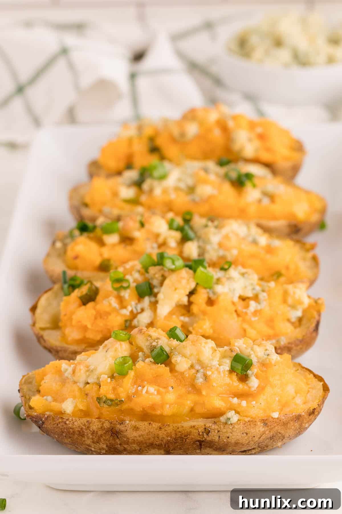 Buffalo Stuffed Potatoes 3 Buffalo Twice Baked Potatoes arranged on an elegant white platter, garnished with fresh green onions, ready for a special occasion.