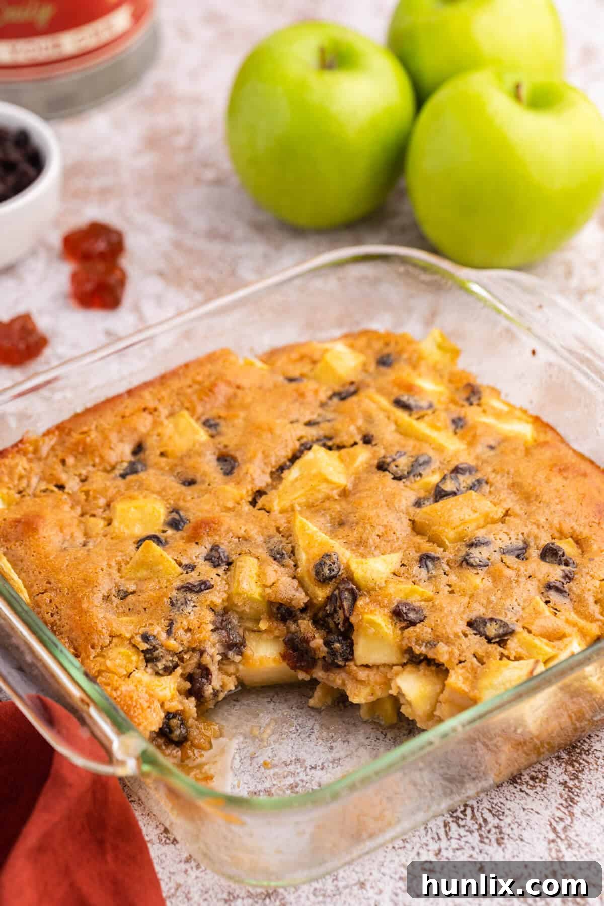 A slice of warm maple apple pudding on a plate, showing its soft interior and baked apple pieces.