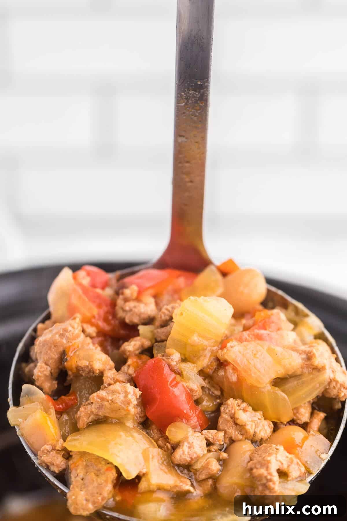 Robust Chicken and Sausage Stew 3 Close-up of a bowl of Chicken and Sausage Soup, garnished with fresh herbs, ready to be served