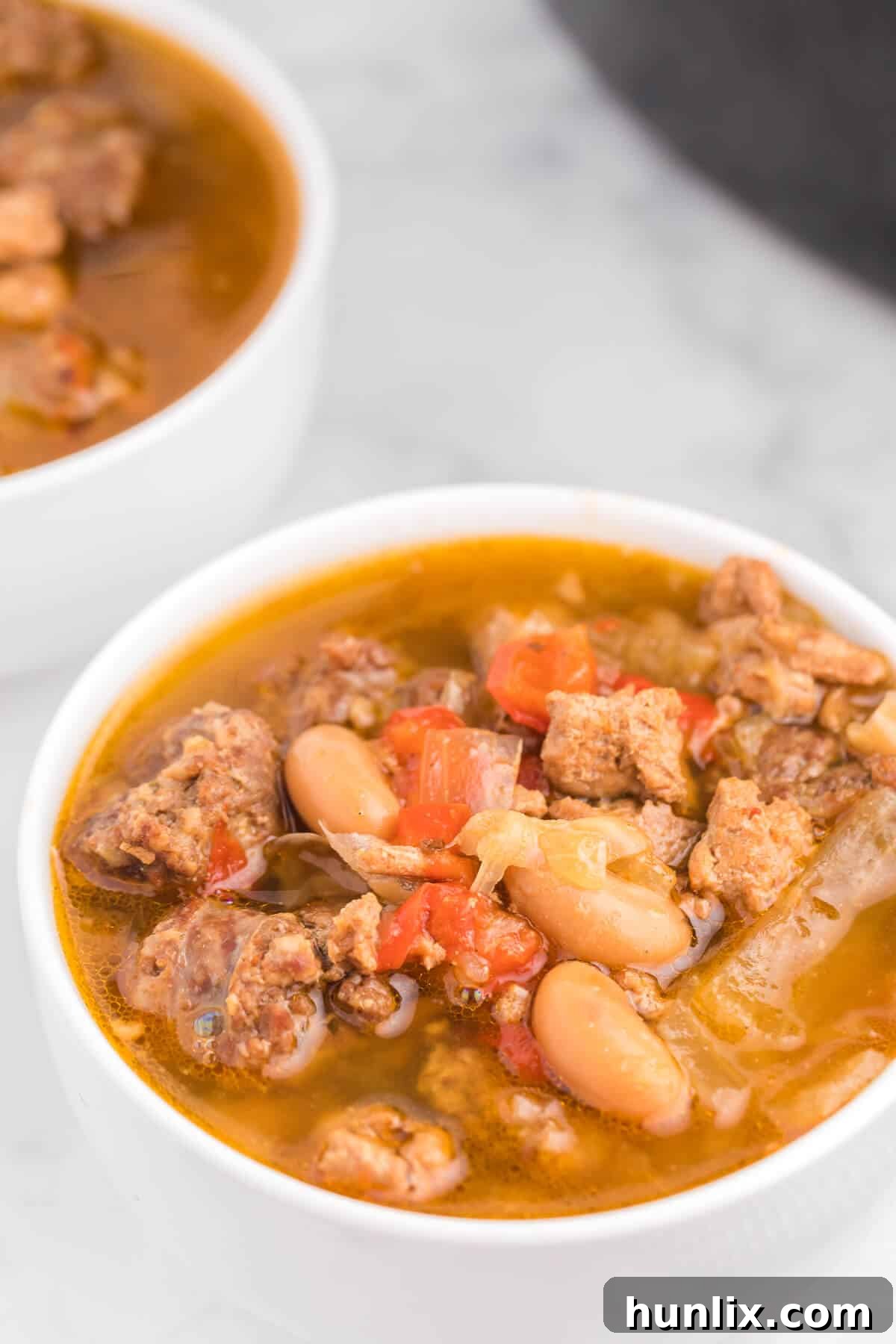 Robust Chicken and Sausage Stew 5 Overhead shot of Slow Cooker Chicken and Sausage Soup in a large serving pot, with bowls ready to be filled