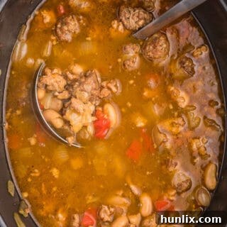 Robust Chicken and Sausage Stew 6 A comforting bowl of Slow Cooker Chicken Sausage Soup, perfect for a cold day, garnished with a sprinkle of fresh parsley