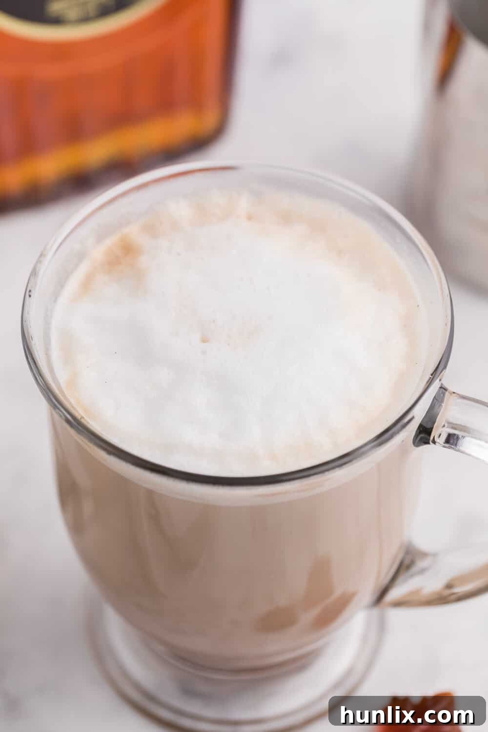 A cozy mug of maple latte, garnished with a sprinkle of cinnamon, resting on a wooden surface.