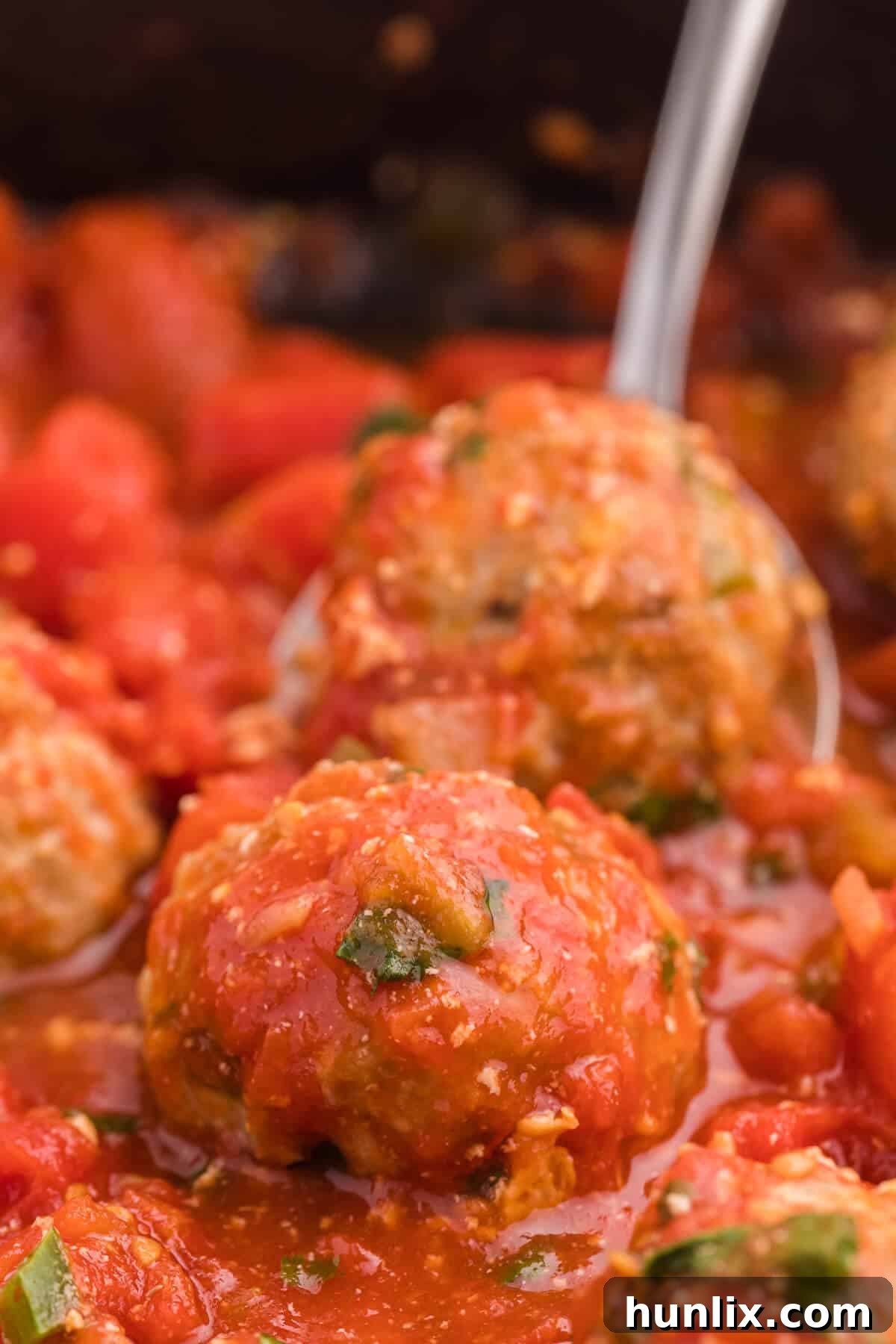 A close-up shot of Mexican meatballs sizzling in a skillet, adorned with fresh cilantro, highlighting their appetizing texture and rich sauce.