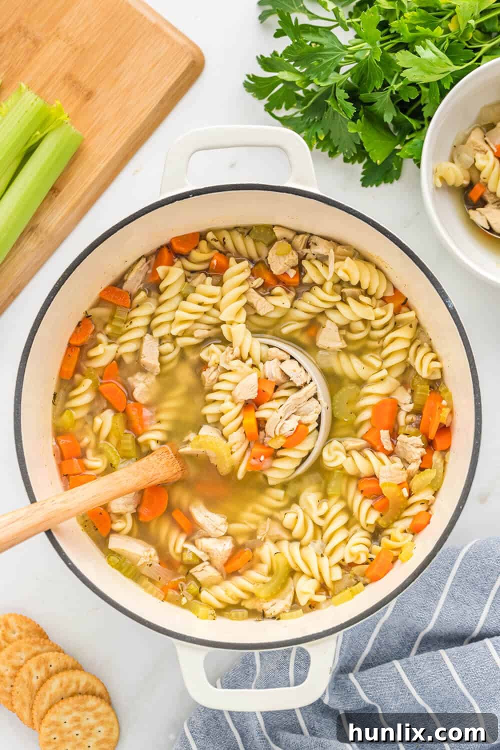 Grandma's Golden Chicken Noodle Soup 2 A large pot of steaming homemade chicken noodle soup with a ladle resting in it, showcasing hearty vegetables and noodles.