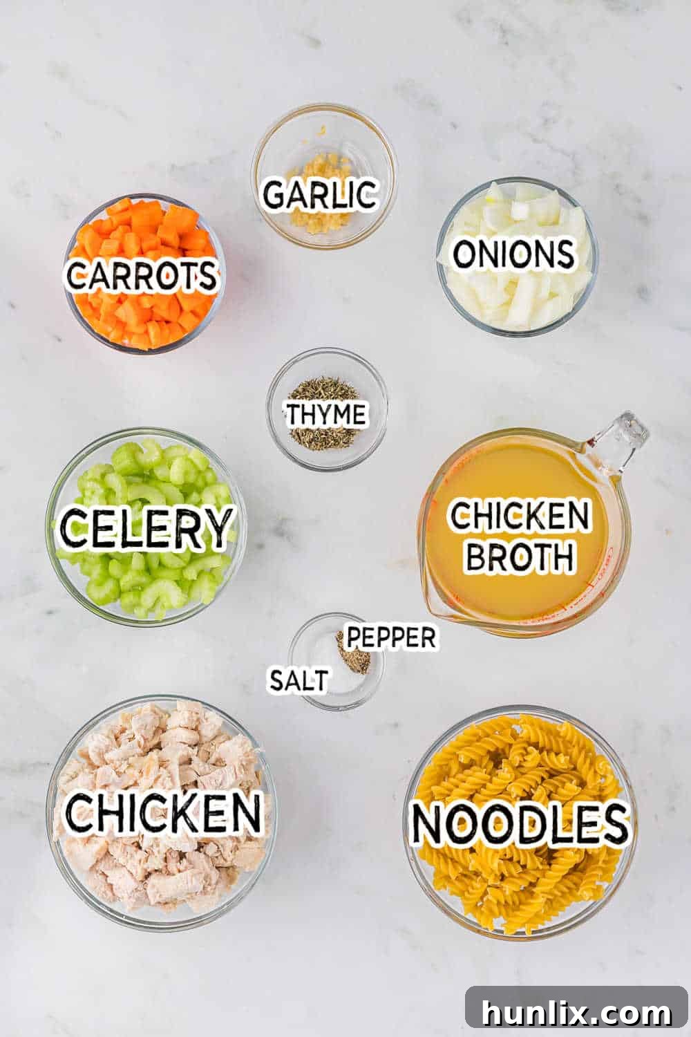 Grandma's Golden Chicken Noodle Soup 3 Fresh ingredients for homemade chicken noodle soup, including chopped celery, carrots, onion, garlic, and a sprig of thyme.