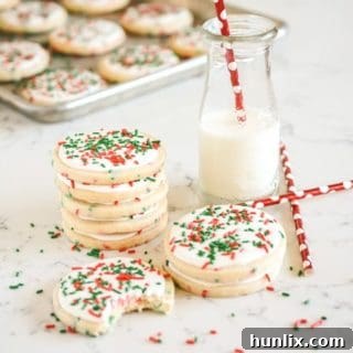 Soft and chewy Christmas confetti sugar cookies adorned with colorful festive sprinkles.