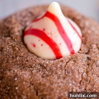 Festive candy cane kiss cookies with a chocolate base and peppermint kiss topping.