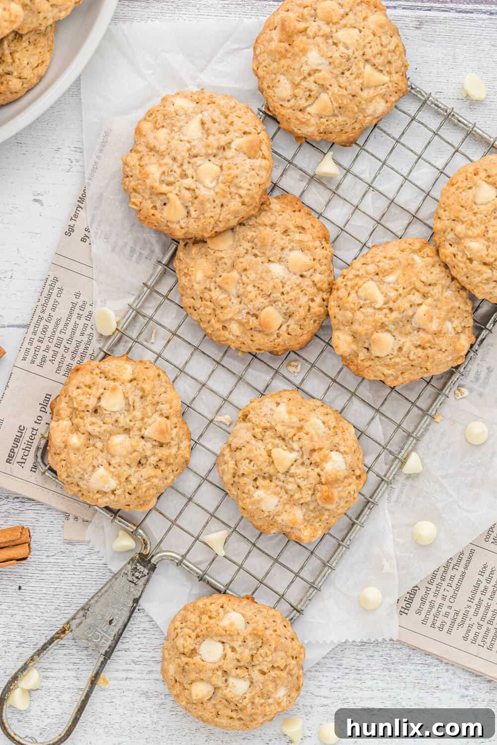 Close-up view of freshly baked white chocolate oatmeal cookies arranged neatly on a wire cooling rack, highlighting their texture and the melty white chocolate chips.