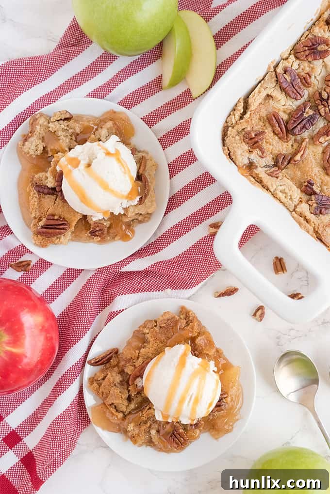 Effortless Caramel Apple Delight 7 Plates of caramel apple dump cake topped with vanilla ice cream, arranged on a surface with festive red and white linens, ready for serving.