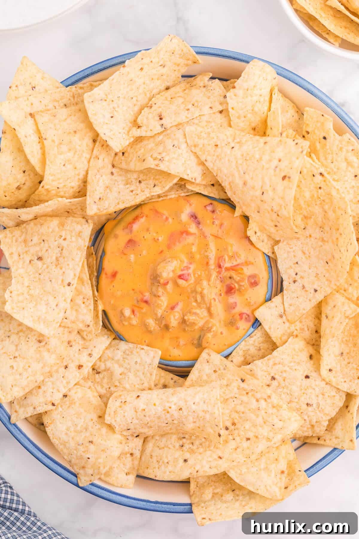 Ultimate Chicken Queso 2 Creamy Chicken Queso Dip served in a bowl with tortilla chips, perfect for dipping.