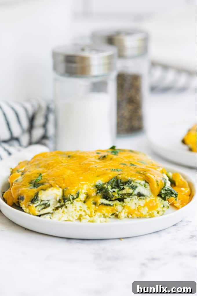 A bowl of whisked eggs and milk, with spinach, feta, and Parmesan cheese added, ready to be stirred for the Slow Cooker Spinach & Feta Quiche.