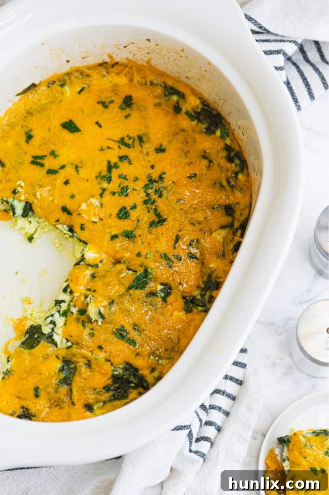 A slice of Slow Cooker Spinach & Feta Quiche on a plate, showing its rich texture with visible spinach and cheese.