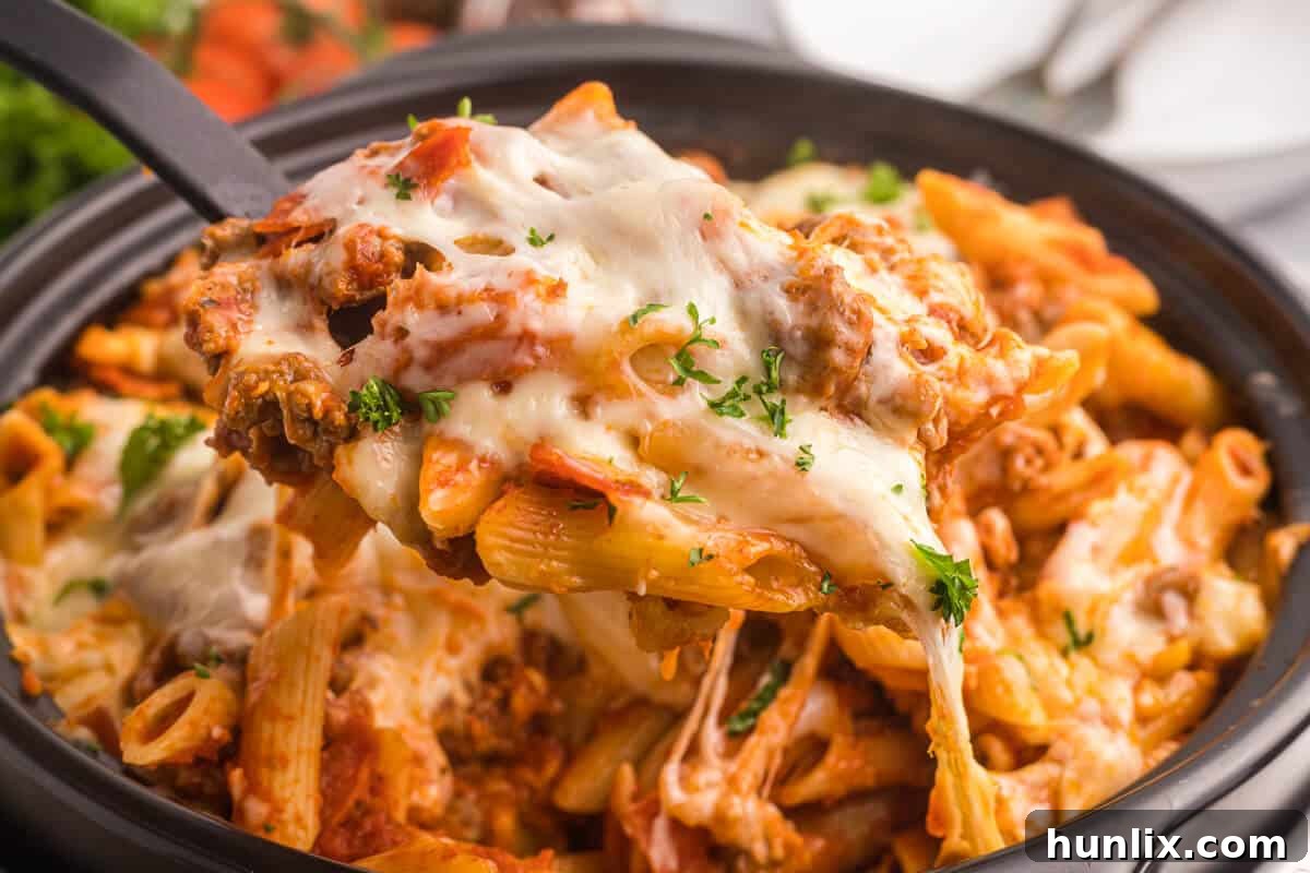 Close-up of slow cooker pizza pasta served in a bowl, showing the rich sauce and melted cheese.