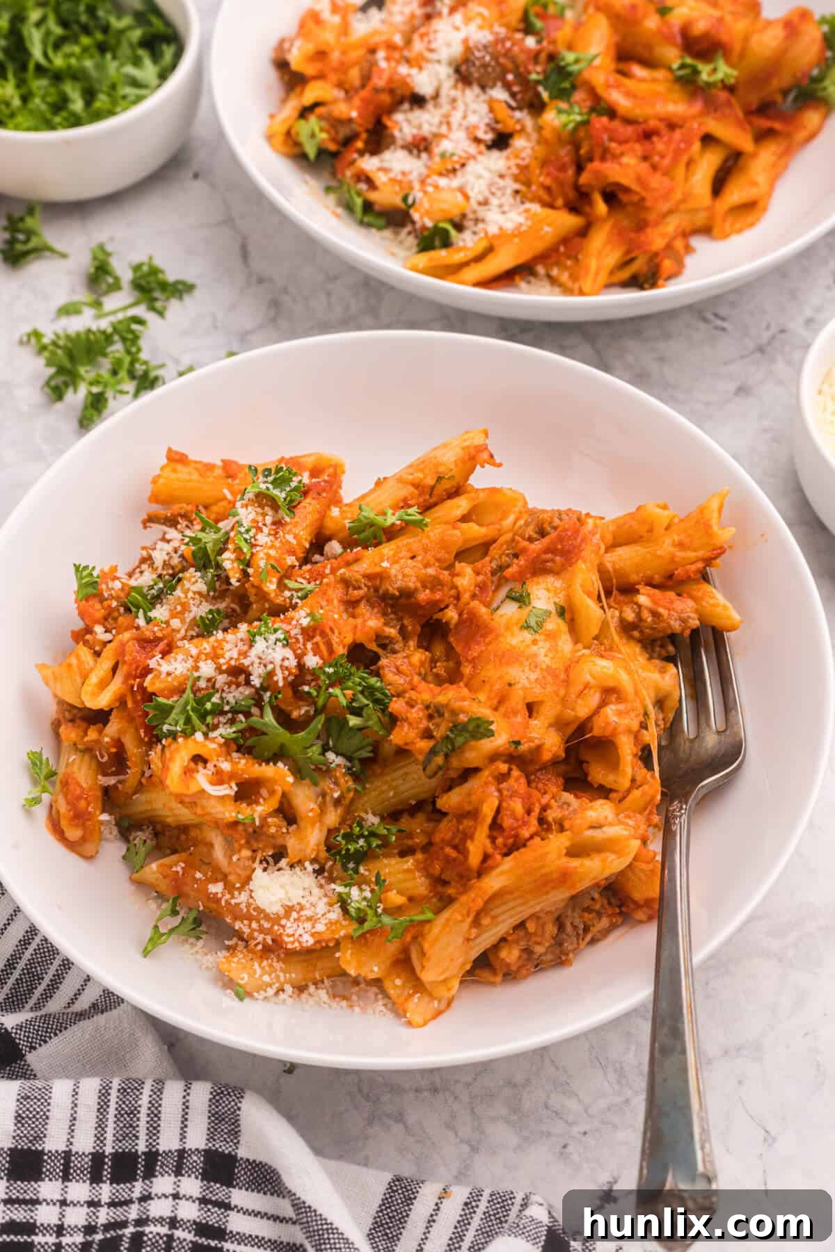 A delicious serving of slow cooker pizza pasta in a bowl with a fork ready to eat.