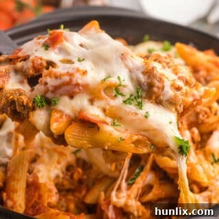 Slow cooker pizza pasta with a serving spoon.