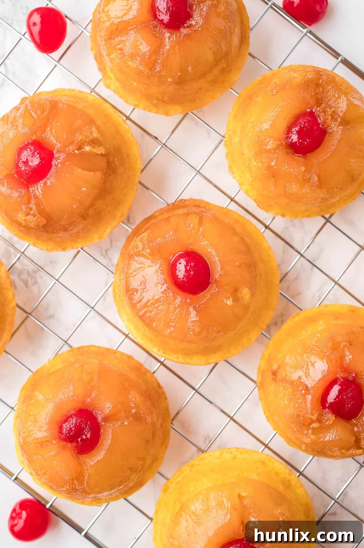 Pineapple upside down cupcakes on a wire rack.